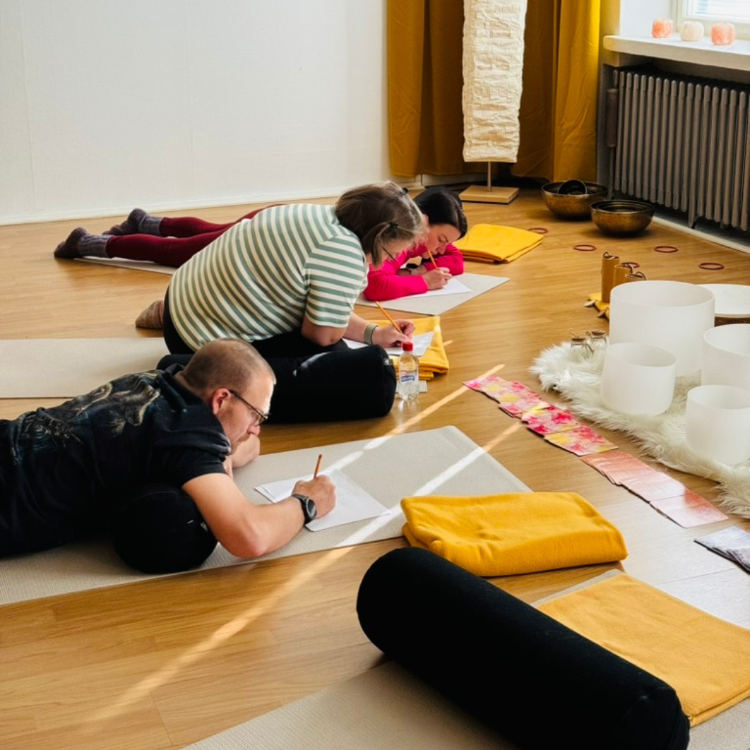 ihmisiä lattialla kirjoittamassa
